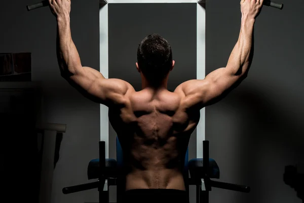 Ağır egzersiz yaparak genç erkek vücut geliştirmeci — Stok fotoğraf
