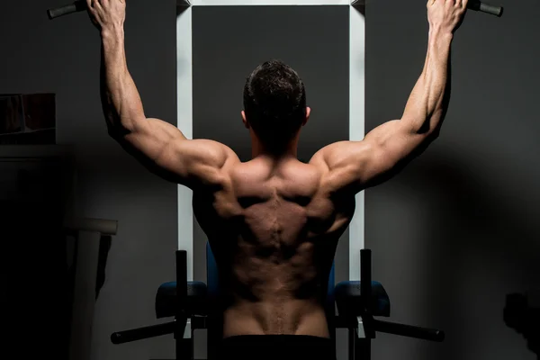 Joven culturista masculino haciendo ejercicio de peso pesado — Foto de Stock