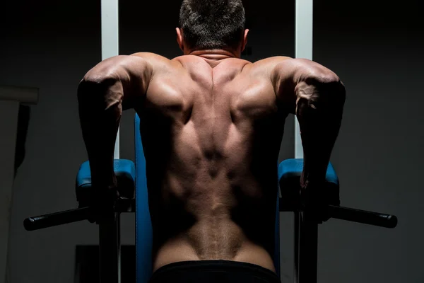 Young male bodybuilder doing heavy weight exercise — Stock Photo, Image