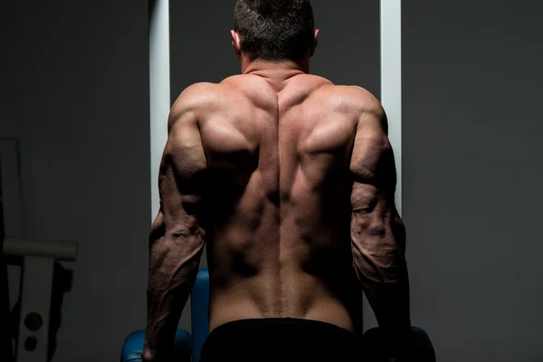 Young male bodybuilder doing heavy weight exercise — Stock Photo, Image