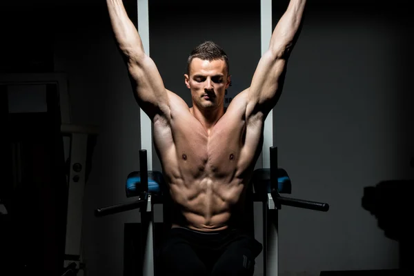 Hombre guapo ejercitando sus abdominales en el gimnasio —  Fotos de Stock