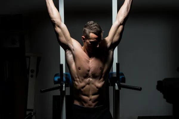 Hombre guapo ejercitando sus abdominales en el gimnasio —  Fotos de Stock