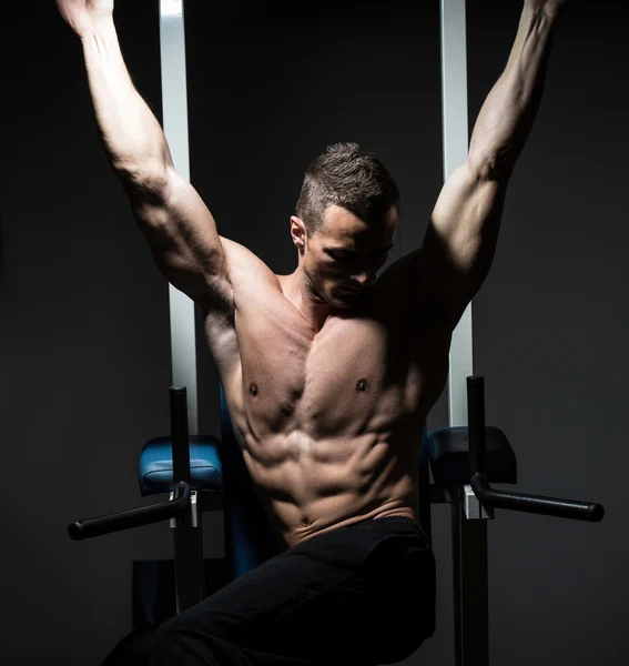 Yakışıklı bir adam onun abs spor salonunda egzersiz — Stok fotoğraf