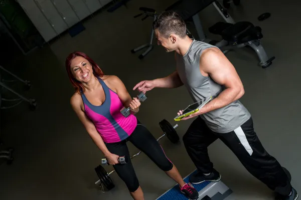 Entrenador personal motivando a la mujer en el gimnasio —  Fotos de Stock