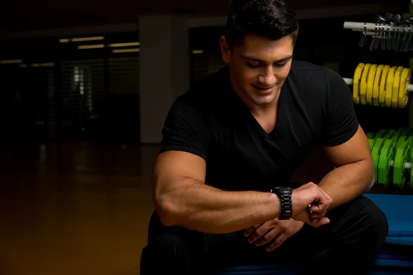 Joven mostrando en el reloj, es hora de entrenar —  Fotos de Stock