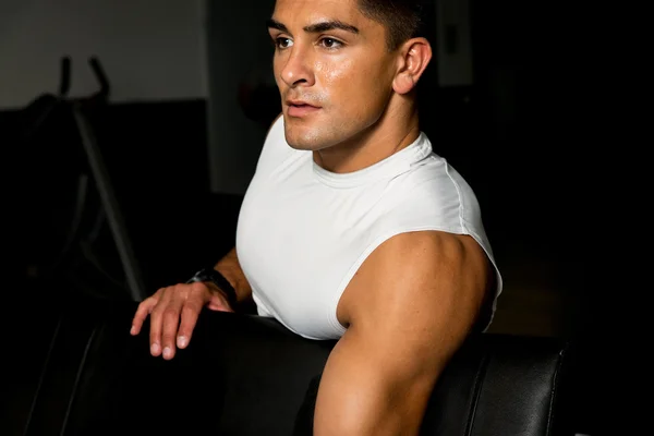 Young man in gym exercising with dumbbells — Stock Photo, Image