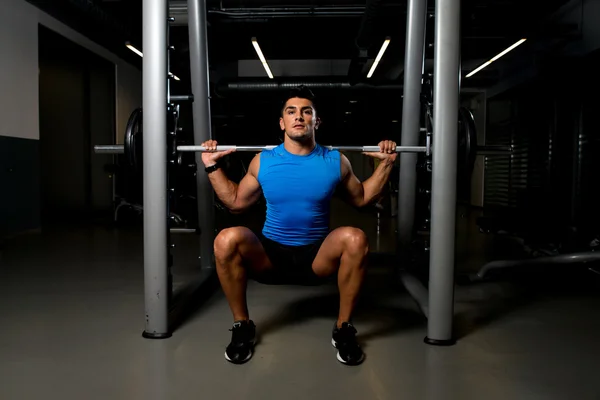 Mladý muž, cvičení s squaty barbell — Stock fotografie