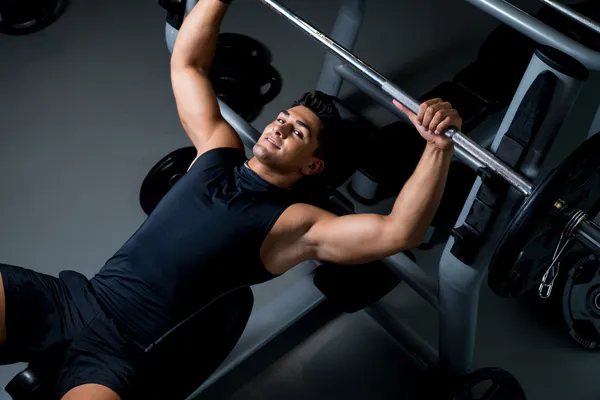 Handsome young bodybuilder smilingly prepares for exercise — Stock Photo, Image