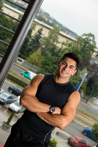 Homem está sorrindo e olhando para a câmera no ginásio — Fotografia de Stock