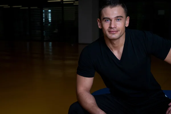 Portrait d'un homme heureux tout en se relaxant dans une salle de gym — Photo