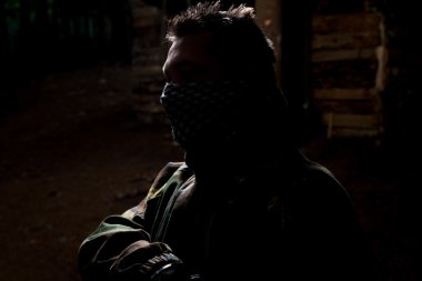 jugador de paintball posando para el fondo de la cámara negra