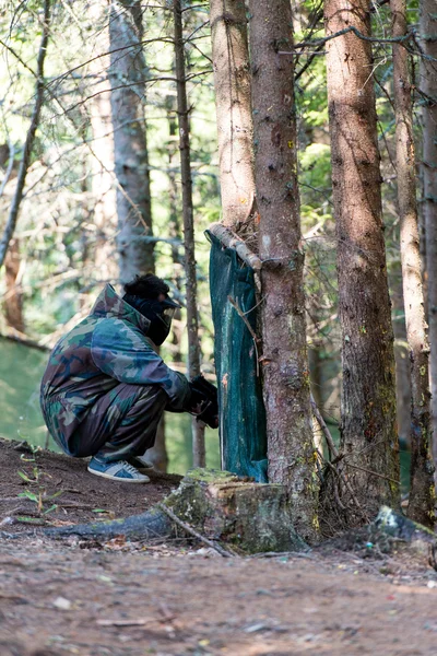 Пейнтбольные игроки прячутся за деревом — стоковое фото