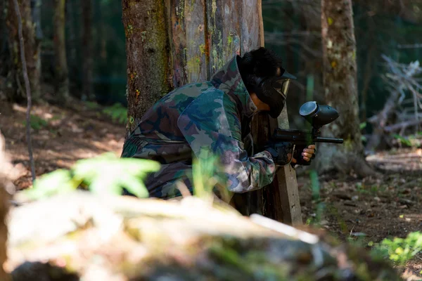 Les joueurs de paintball se cachent derrière l'arbre — Photo