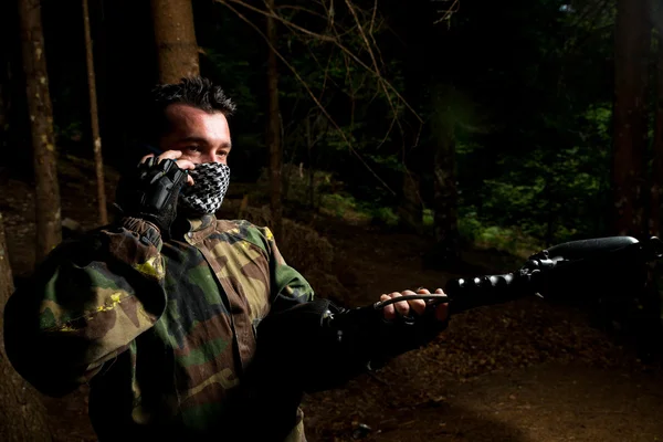 Paintball speler bellen met iemand op de telefoon — Stockfoto