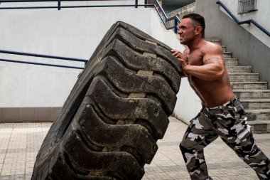 kaslı erkek bir çapraz uygun egzersiz lastiği yaparak katılan fiske vurmak