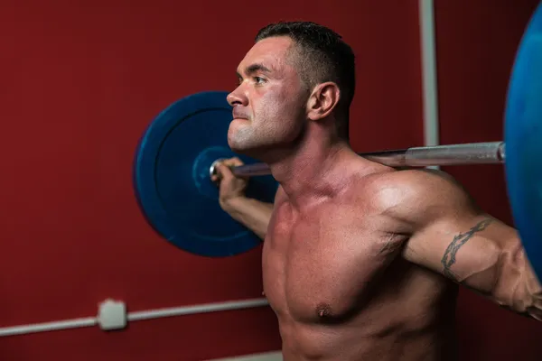 Bodybuilder macht Kniebeugen mit Hanteln — Stockfoto