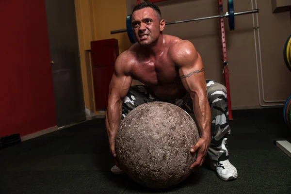 Bodybuilder versucht sich an einer Übung zum starken Mann — Stockfoto