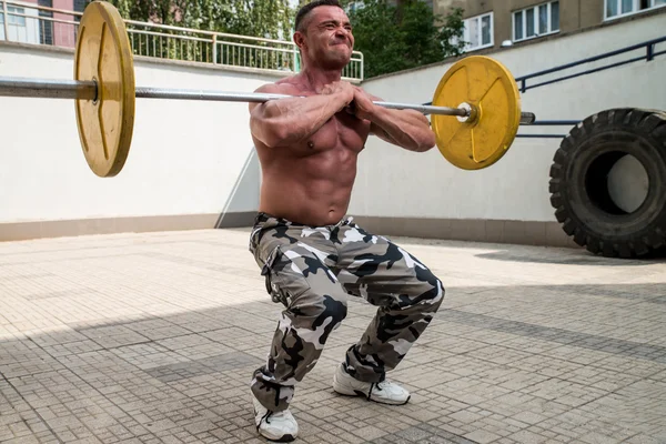 Bodybuilder faire avant squats avec des cloches — Photo