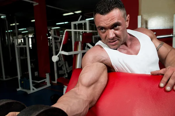 Muskulöser Mann beim Training im Fitnessstudio — Stockfoto
