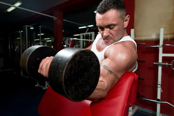 Potente musculoso hombre levantando pesas — Foto de Stock
