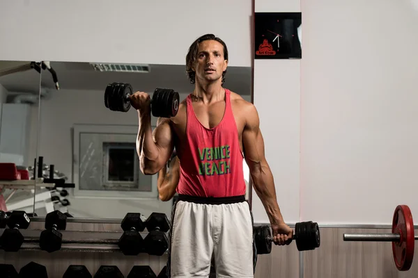 Muskulöser Mann beim Training im Fitnessstudio — Stockfoto