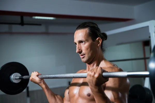 Mann im Fitnessstudio trainiert Bizeps mit Langhantel — Stockfoto