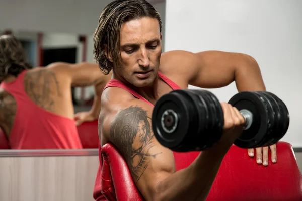 Potente musculoso hombre levantando pesas — Foto de Stock