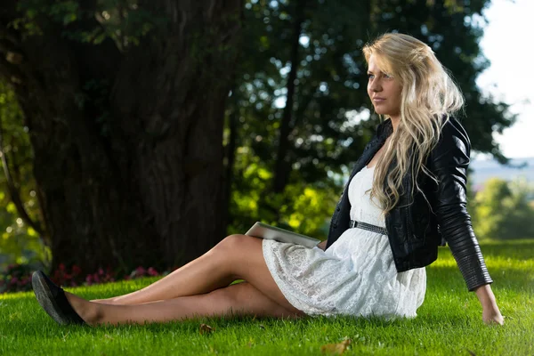 Pretty Woman Sitting On The Grass With Digital Tablet — Stock Photo, Image