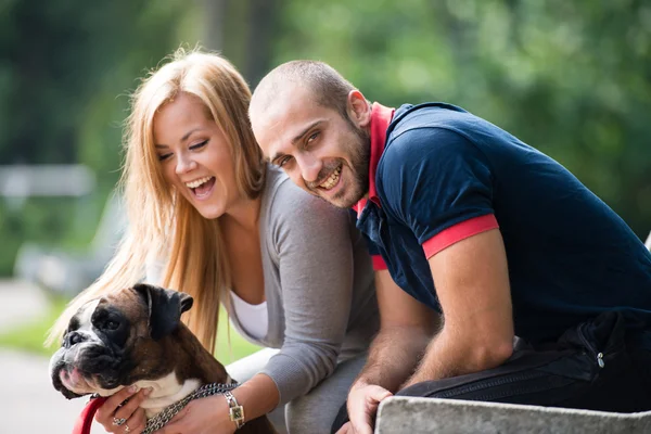 Lyckliga paret med Tysk boxare — Stockfoto