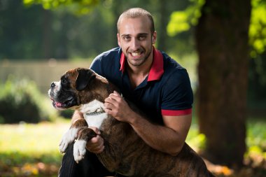 Köpekle oynayan adam.