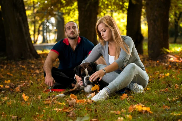 Paar sitzt mit Hund im Freien — Stockfoto