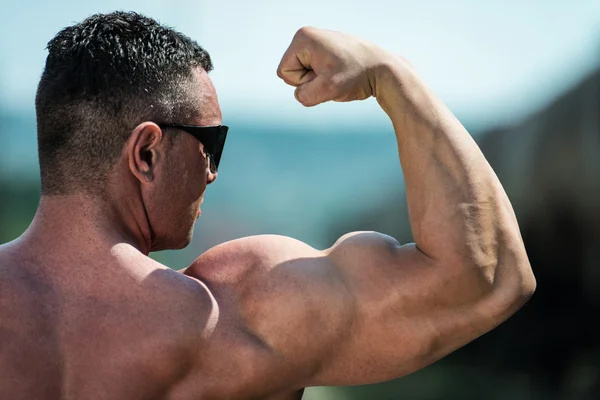 Mann atlet som viser biceps – stockfoto
