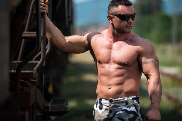 Male Bodybuilder Holding On To Train — Stock Photo, Image