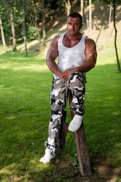 Bodybuilder poseren in een veld — Stockfoto