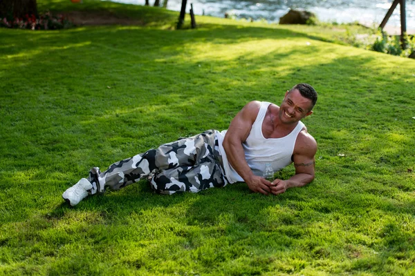 Homem segurando garrafa de água e sorrindo — Fotografia de Stock