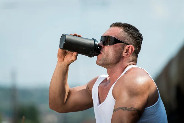 Bodybuilder rusten en eiwit shake drinken — Stockfoto