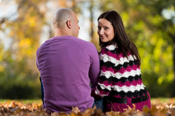 Glückliches Paar sitzt im Herbst zusammen im Wald — Stockfoto