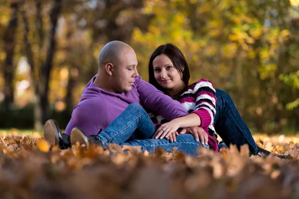 Affascinante coppia sdraiato insieme al parco — Foto Stock
