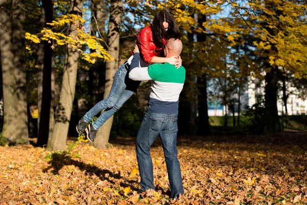 Homme portant femme balade à travers les bois d'automne — Photo