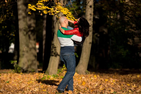 Homme portant femme balade à travers les bois d'automne — Photo