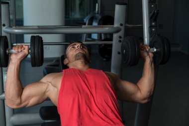 eğimli göğüs Pres jimnastik salonu içinde dumbbells ile yapan erkek