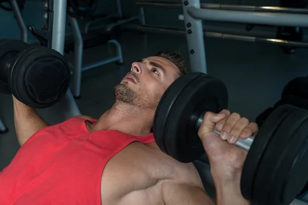 Man Lies On A Bench And Does Dumbbell Presses — Stock Photo, Image