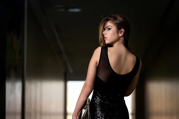 Güzel siyah elbiseli arkadan bir modeldir — Stok fotoğraf
