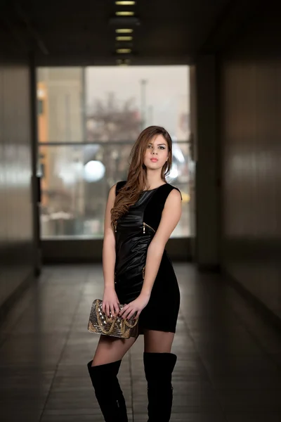 Сексуальная девушка в кожаном платье с сумкой — стоковое фото