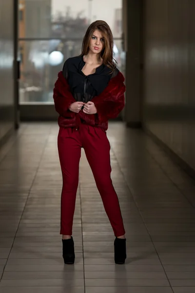 Modelo de moda glamour vestindo calças vermelhas e casaco — Fotografia de Stock