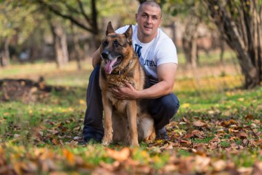 Alman çoban köpeği olan adam