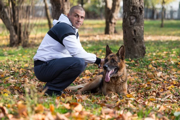 Homem com cão pastor alemão — Fotografia de Stock