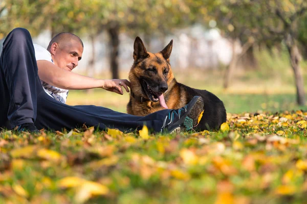 Homem com cão pastor alemão — Fotografia de Stock