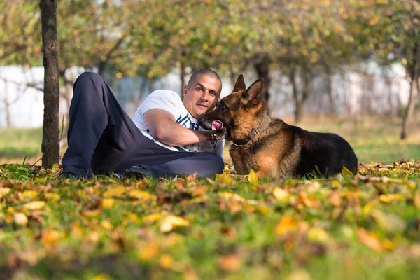 Vuxen man sitter utomhus med sin Schäfer — Stockfoto