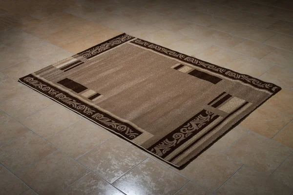 Один коричневый ковер, сложенный на полу — стоковое фото